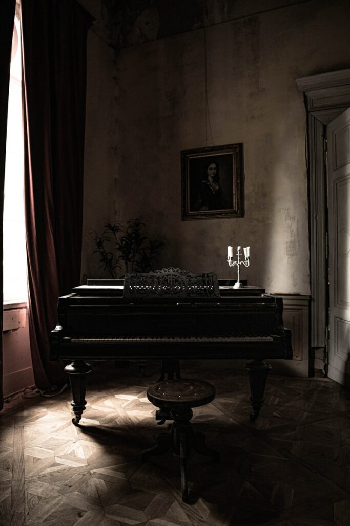 black grand piano near red curtain